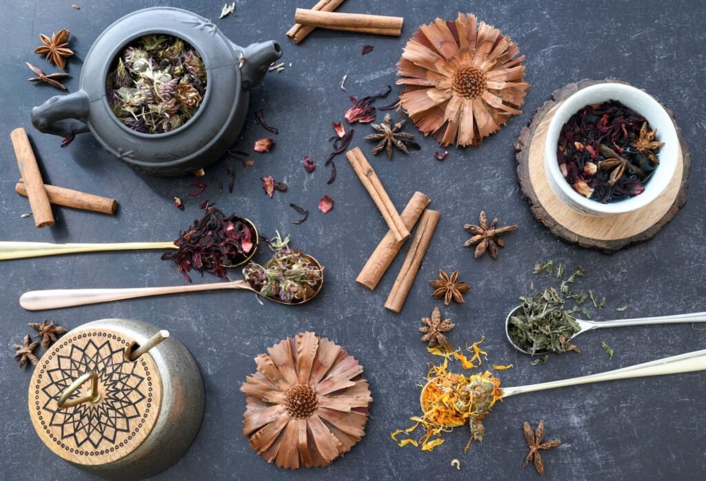 Herbal tea ingredients, dried flowers, cinnamon and star anise on slate
